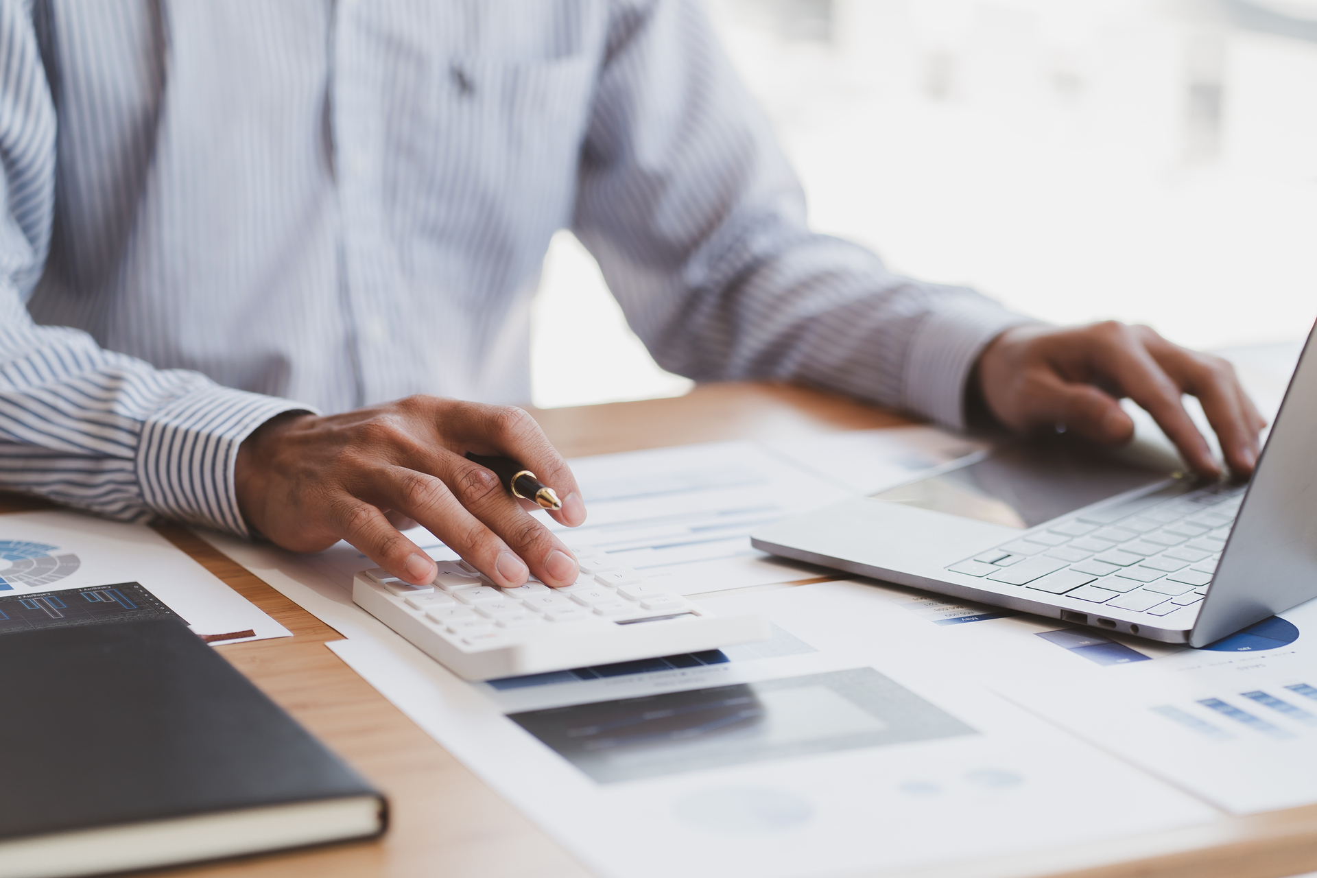 1920-businessman-or-accountant-working-on-calculator-to-calculate-business-data-concept-accounting-investment-advisor-consulting-situation-on-the-financial-report-and-planning-a-marketing-plan-at-office.JPG