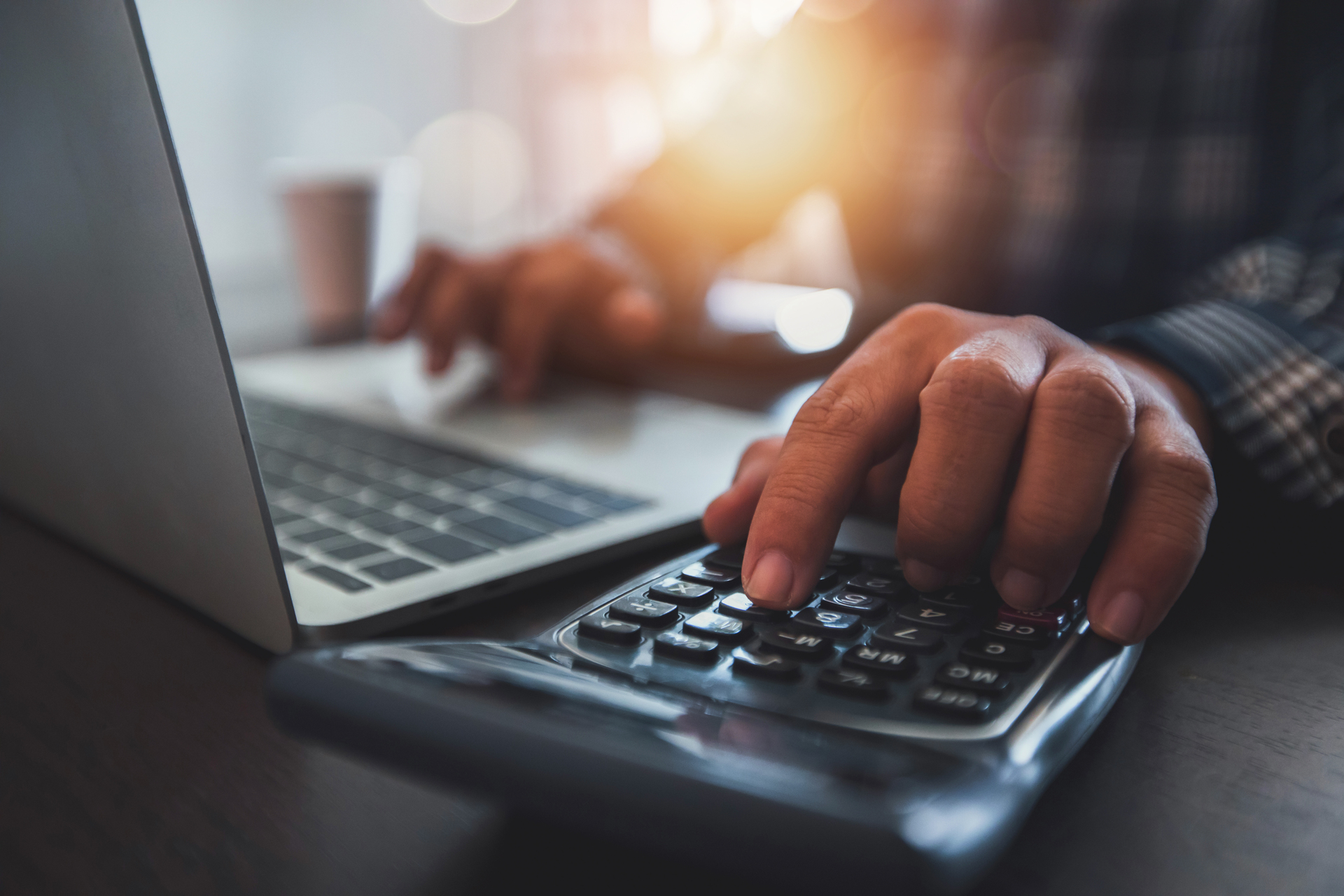 1920-close-up-of-businessman-s-hand-using-calculator-and-working-on-laptop.JPG