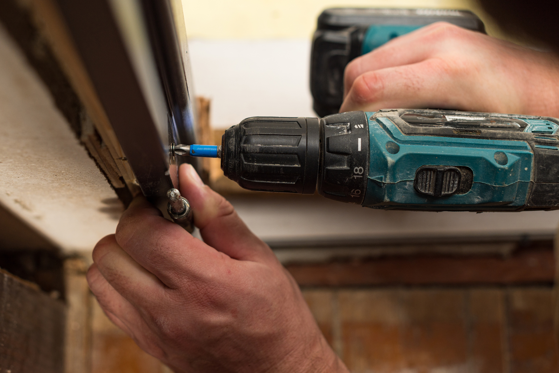 1920-drilling-and-installation-of-interior-doors-the-craftsman-makes-a-hole-in-the-door-frame-with-a-hand-drill.jpg