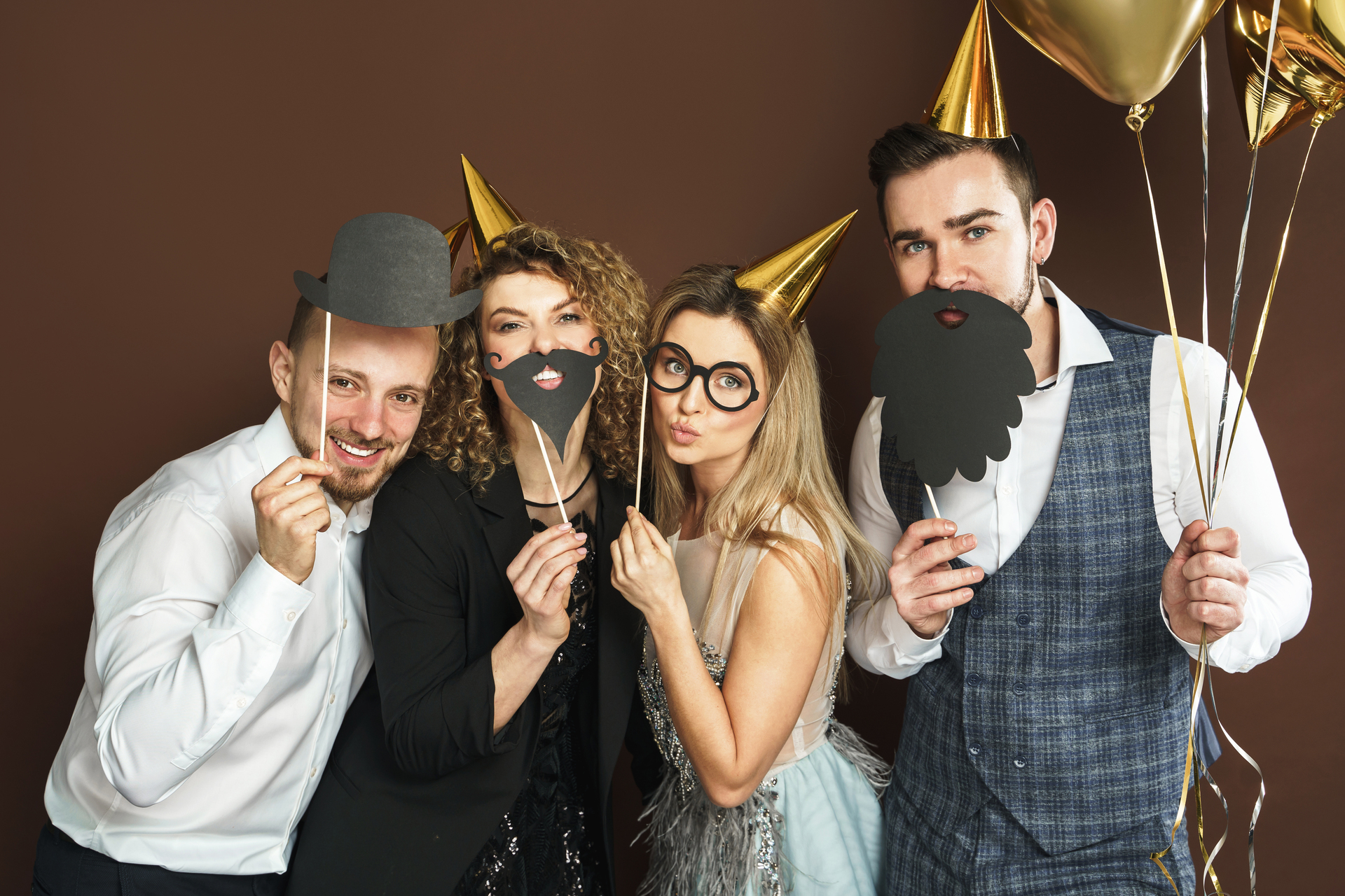 1920-happy-people-wearing-party-hats-with-photo-booth-props-are-celebrating-holiday-or-event.jpg