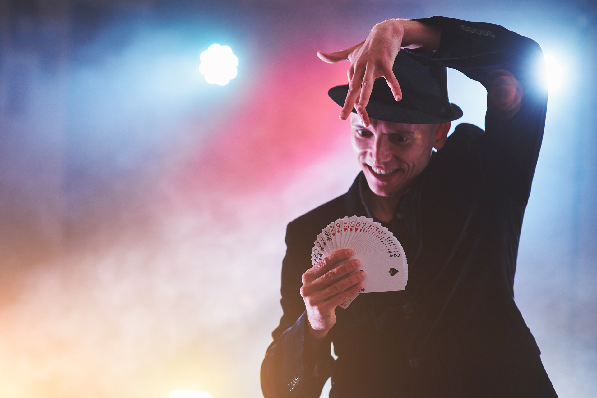 1920-magician-showing-trick-with-playing-cards-magic-or-dexterity-circus-gambling-prestidigitator-in-dark-room-with-fog.jpg