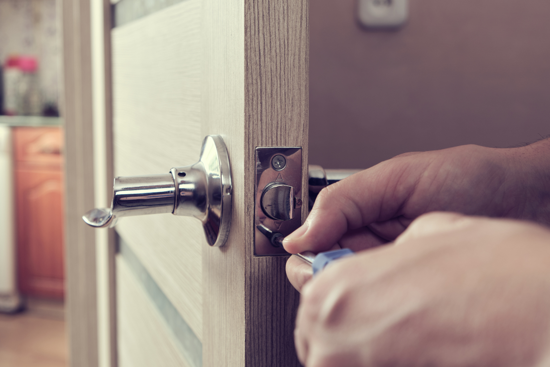 1920-man-repairs-lock-interior-door-with-screwdriver-photo-in-retro-style.jpg