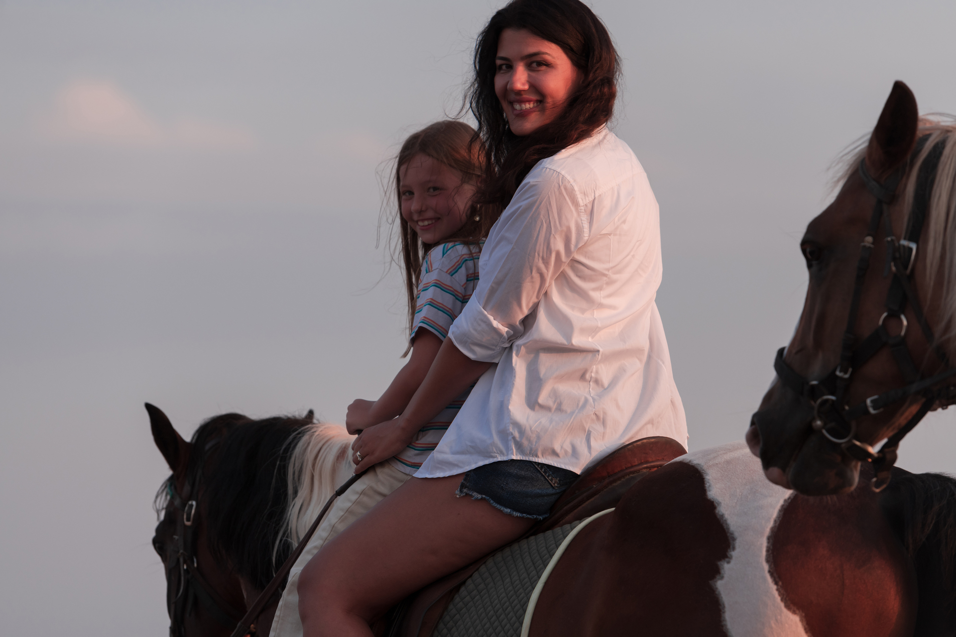 1920-mother-and-daughter-enjoy-riding-horses-together-by-the-sea-selective-focus.jpg