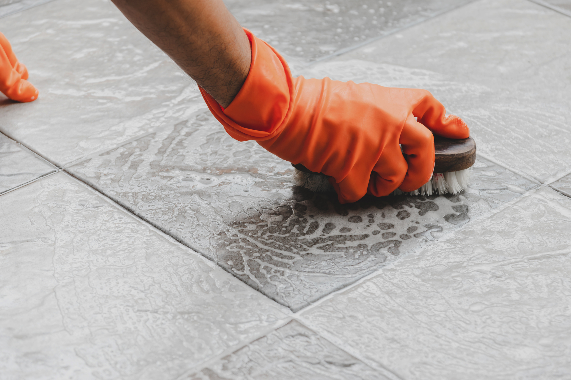 1920-person-with-orange-cleaning-gloves-scrubbing-the-floor.jpg