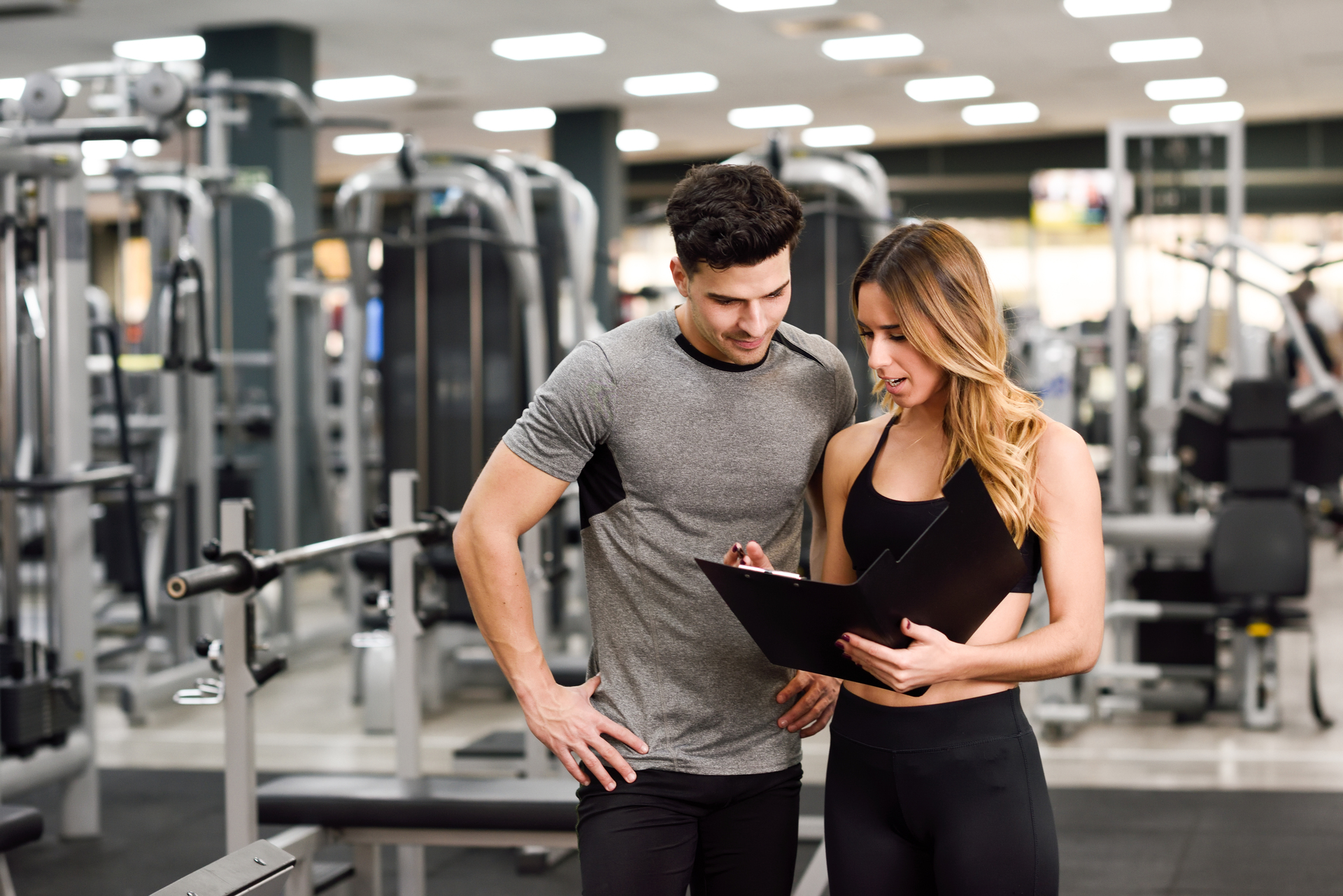 1920-personal-trainer-and-client-looking-at-his-progress-at-the-gym.jpg