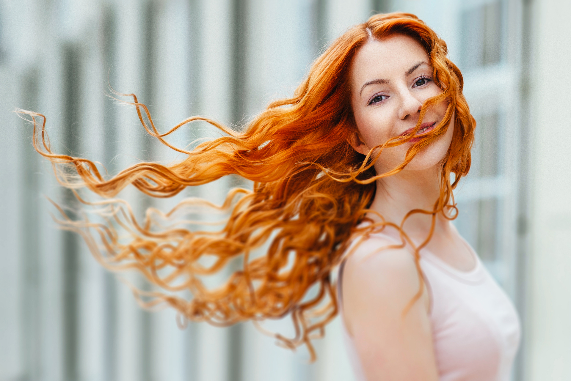 1920-red-haired-young-girl-walking-in-a-park-between-trees-and-architectural-objects.jpg