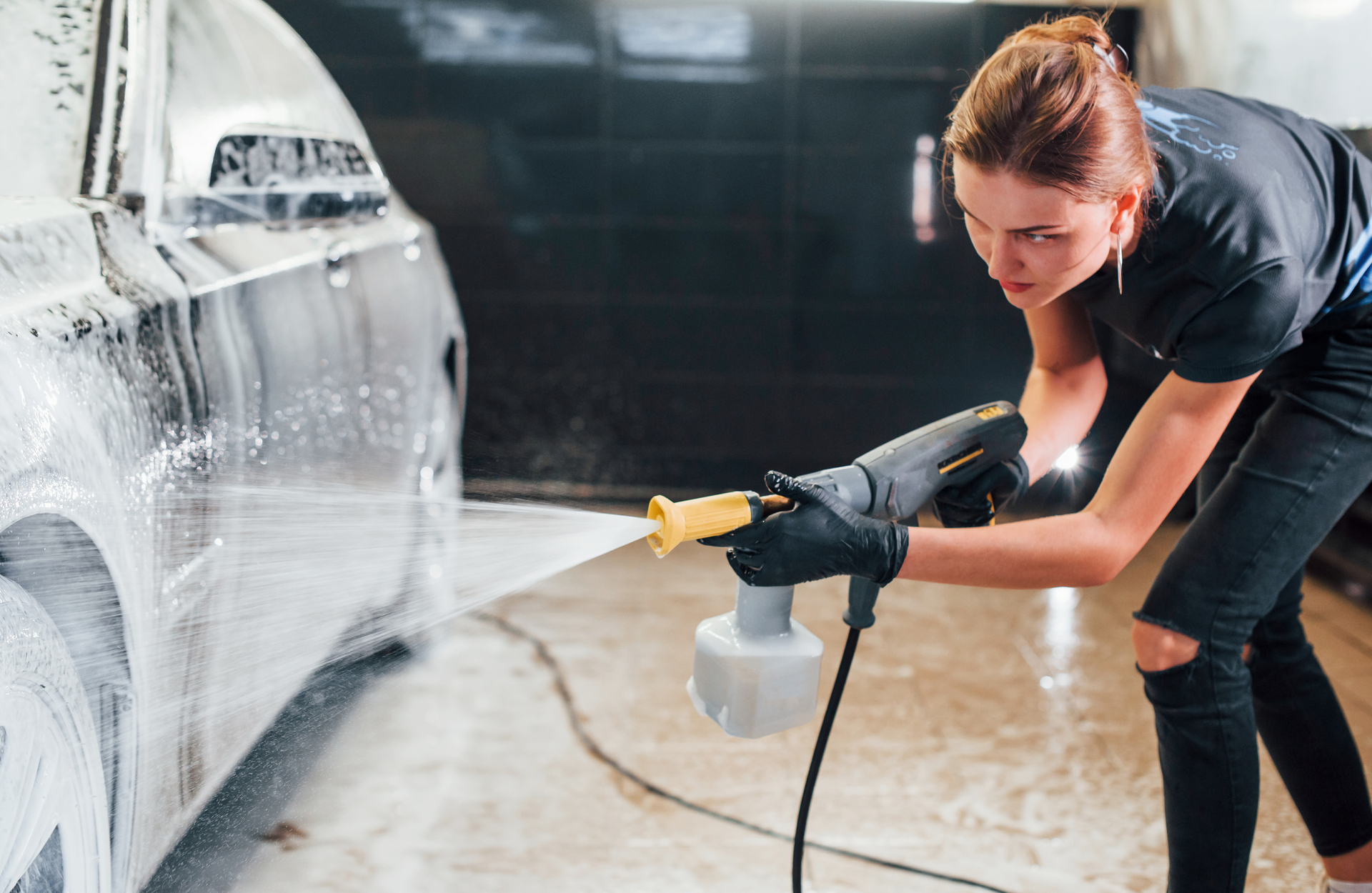 1920-using-high-pressure-water-modern-black-automobile-get-cleaned-by-woman-inside-of-car-wash-station.jpg