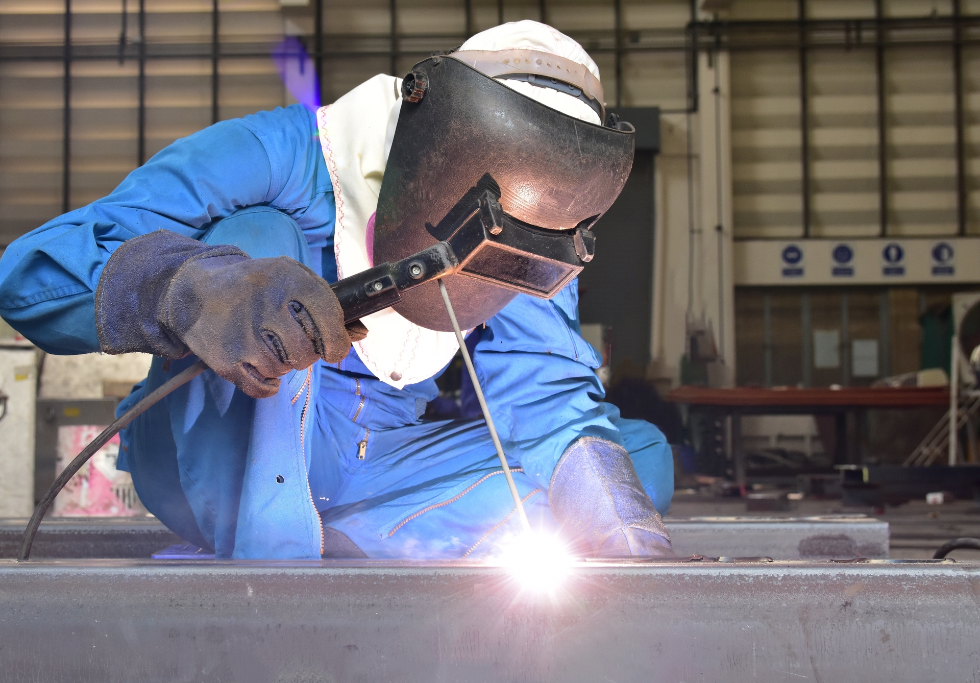 1920-welder-in-blue-uniform-welding-the-workpiece.jpeg