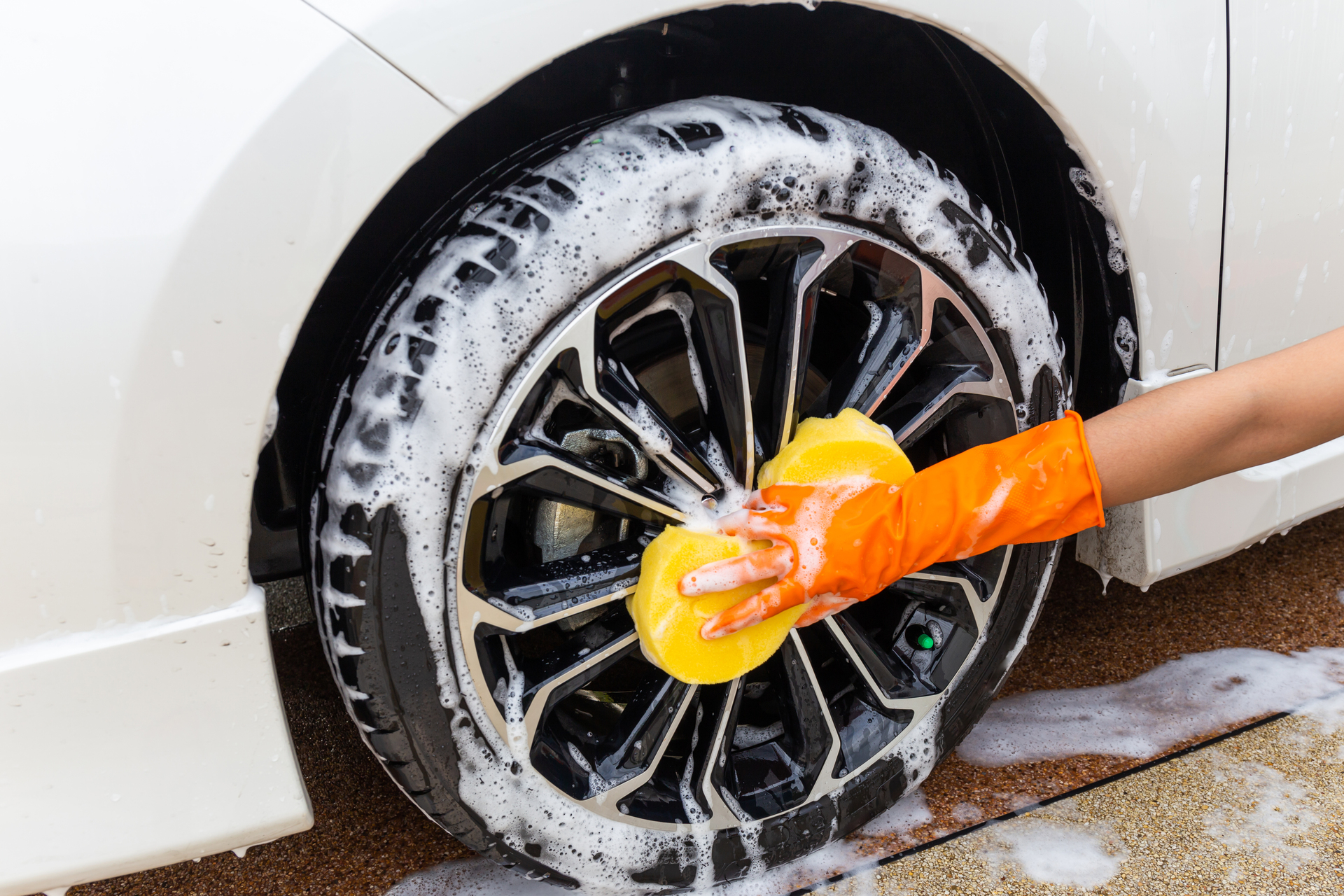 1920-woman-hand-wearing-orange-gloves-with-yellow-sponge-washing-wheel-modern-car-or-cleaning-automobile-car-wash-concept.jpg